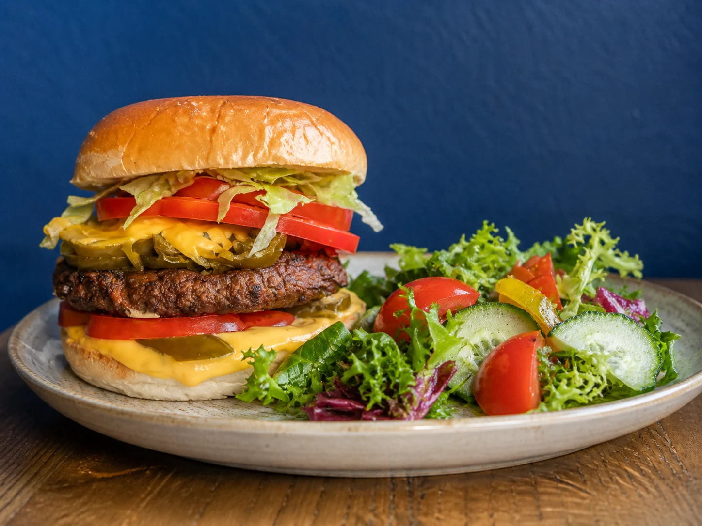 Jalapeño plant-based cheeseburger with a fresh mixed salad